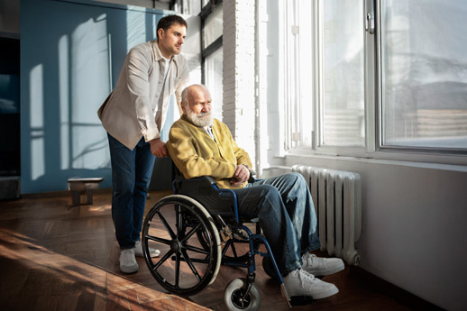 Hombre llevando a otro en silla de ruedas